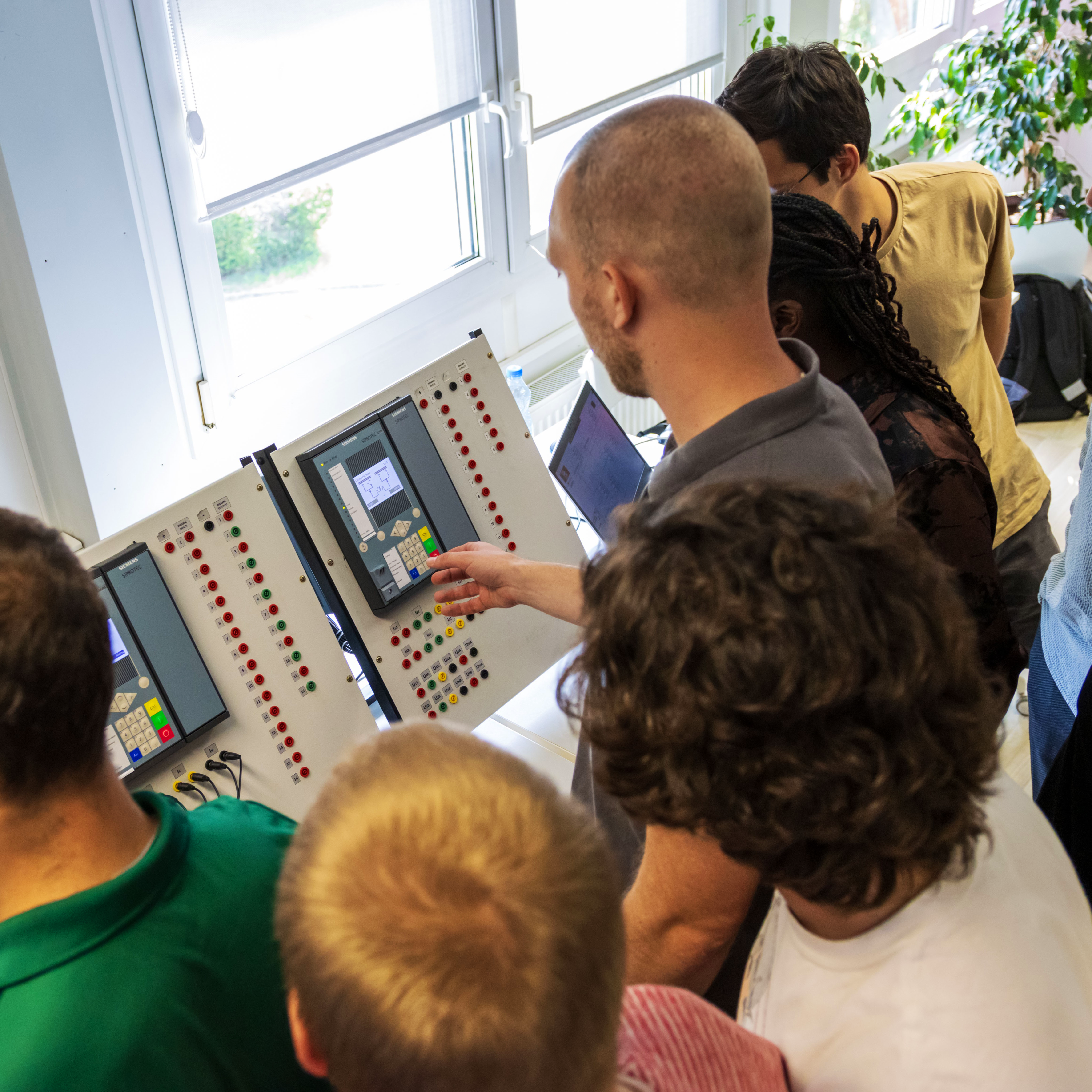 A group of students observes what the lecturer shows them on the dashboard.