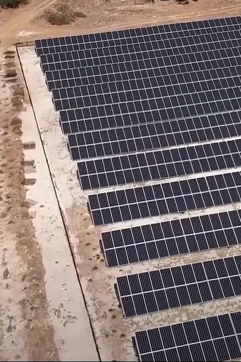 A vast solar farm with neatly arranged rows of solar panels, harnessing the power of the sun for renewable energy generation.