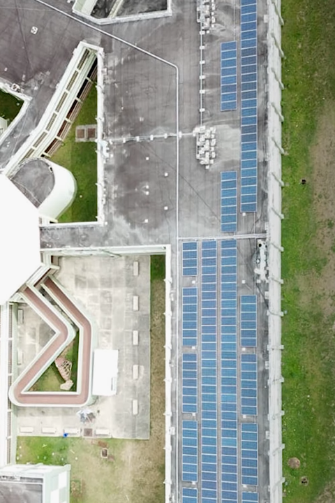 Aerial view of a building with solar panels, harnessing renewable energy for sustainable power generation.