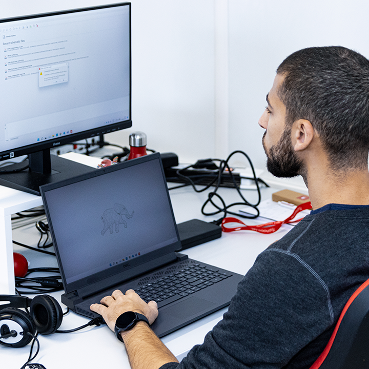 An engineer sitting at a desk with a laptop, focused on his work.